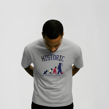 Model wearing Medium BORNGOATD Historic Evolution graphic t-shirt featuring generational progression artwork and “The Record Is Still Being Written” slogan